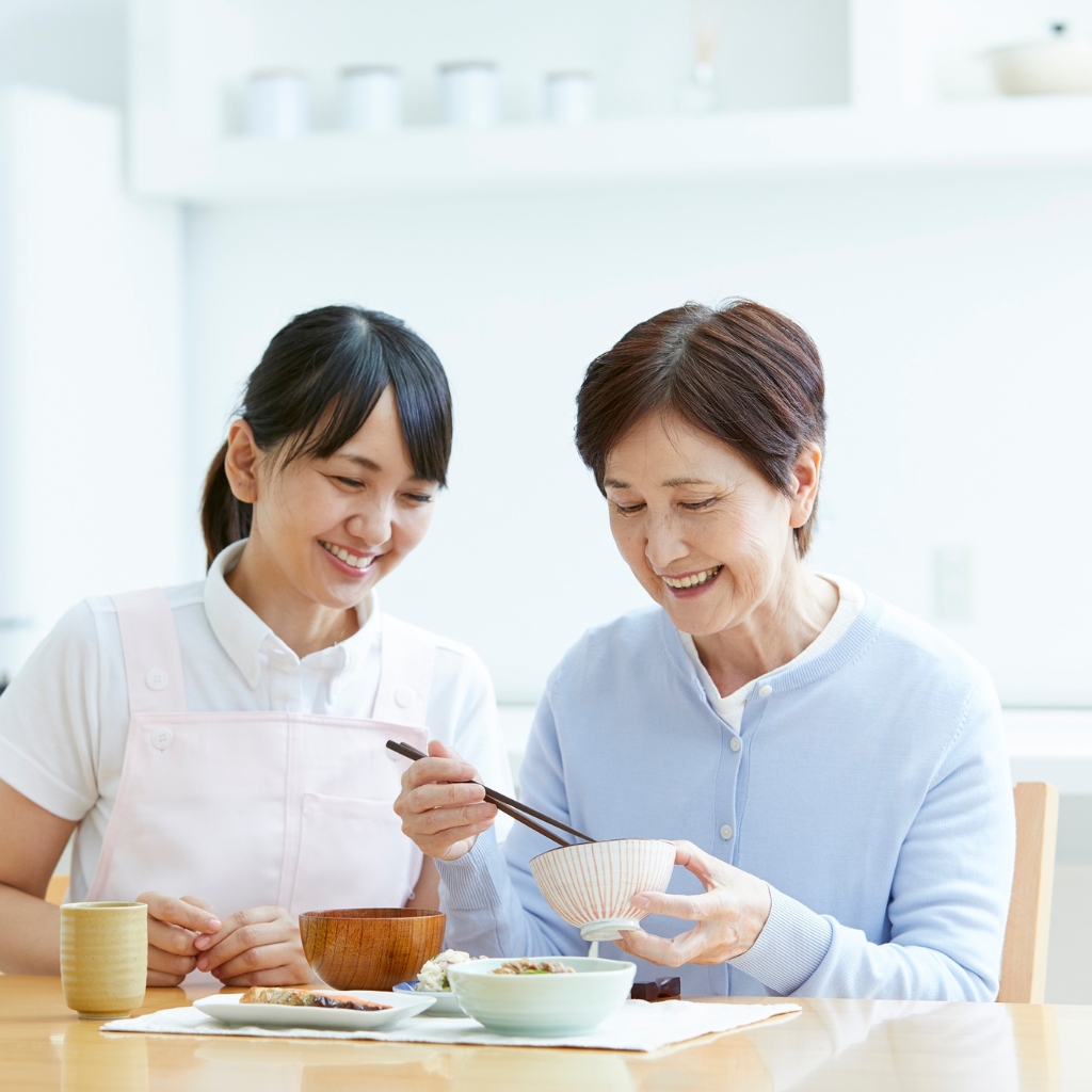 Caregiver interacting warmly with resident in wheelchair at Heart House