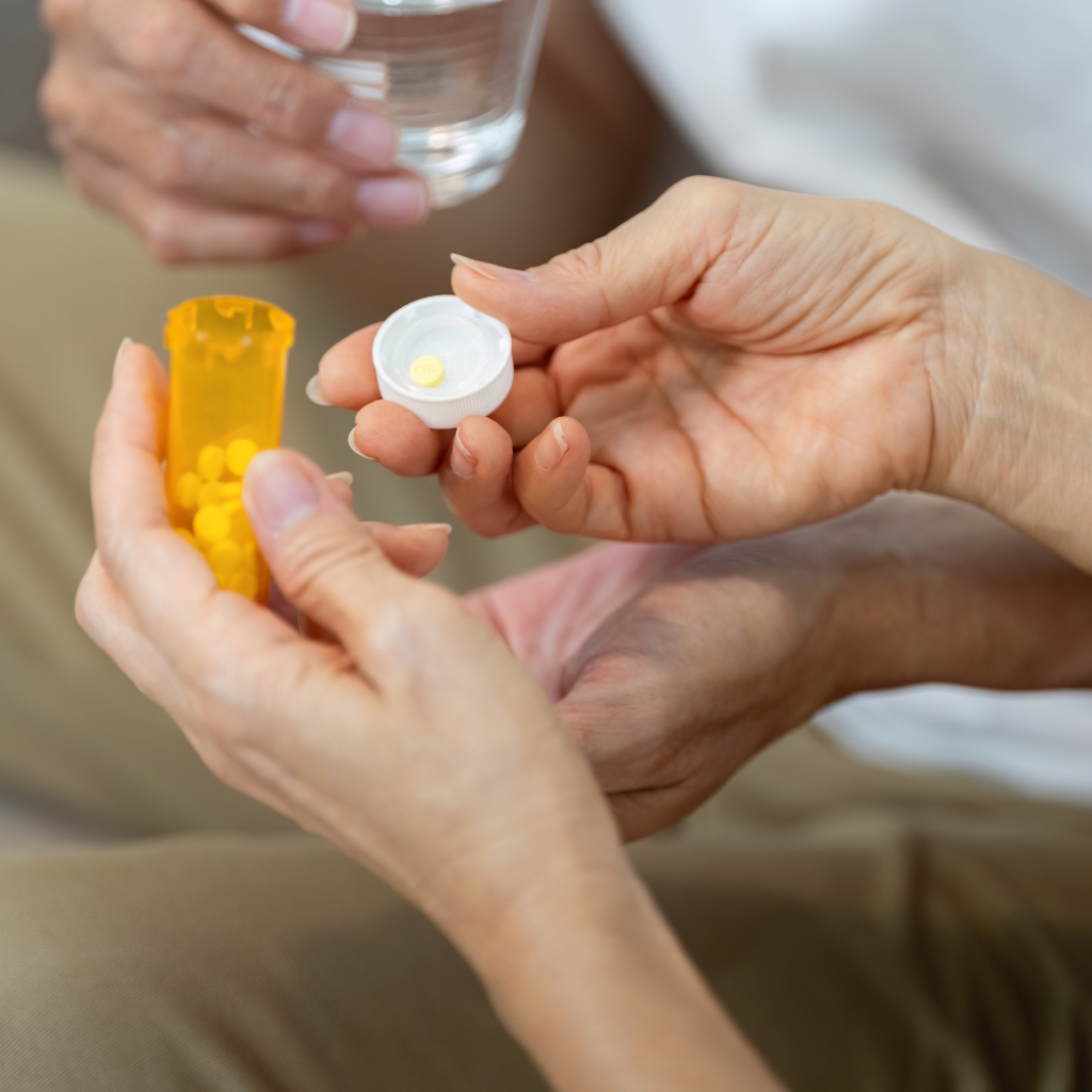 A caregiver providing medication related support to a resident